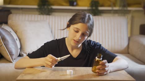 Troubled-young-woman-looking-at-knife-and-pills-in-front-of-her.